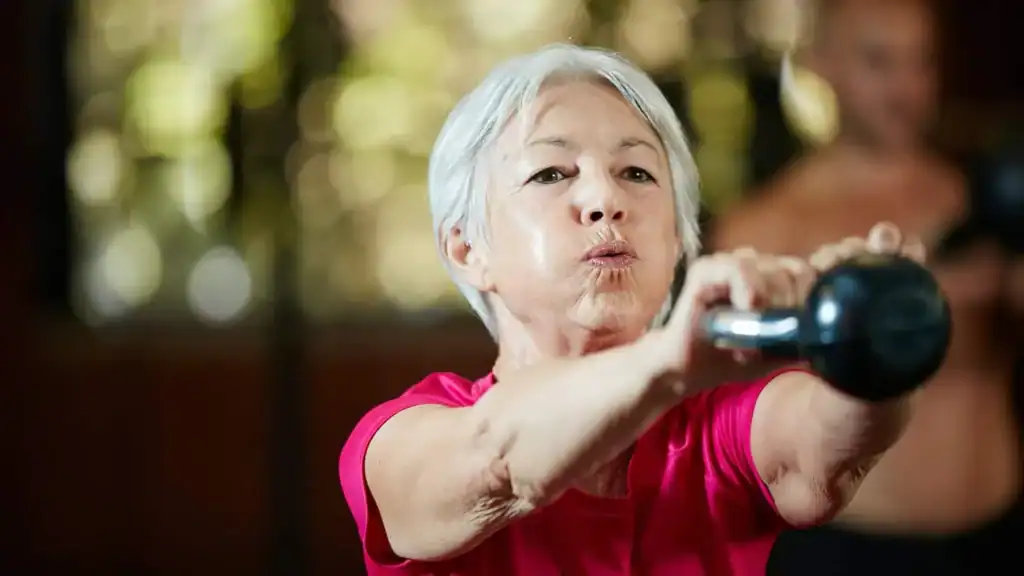 Older woman doing weight training Sevenoaks to help her strength and longevity 