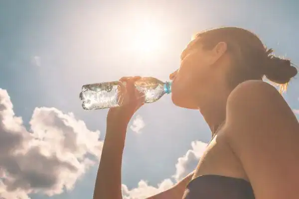 Hydration: The Secret Ingredient for a Toned Stomach and Enhanced Fitness 3 Image of woman drinking water to hydrate Sevenoaks after run.